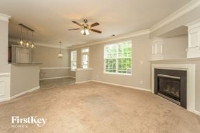 Winston-Salem house for rent - A spacious living room with a fireplace and a ceiling fan.