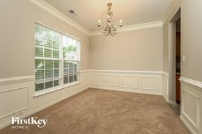 Winston-Salem house for rent - A room with a chandelier, a window with blinds, and a carpeted floor.