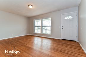 Florissant house for rent - the living room of an empty house with wood floors and a white door