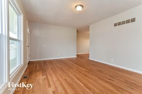 Florissant house for rent - the living room and dining room with hardwood flooring and a large window