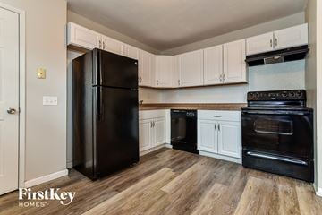Florissant house for rent - a kitchen with black appliances and white cabinets