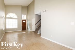 Glendale house for rent - a large empty living room with a staircase and a large window