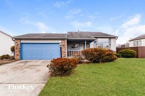 Indianapolis house for rent - A house with a blue garage door is for sale by FirstKey Homes.