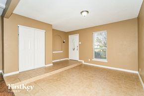 Irving house for rent - A room with a white door and a window with a view of trees.