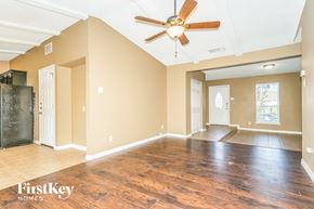 Irving house for rent - A spacious room with wooden floors and a ceiling fan.