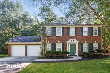 Cumming house for rent - a brick house with a green door and white garage doors