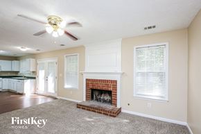 Cumming house for rent - a living room with a fireplace and a ceiling fan