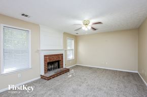 Cumming house for rent - a living room with a fireplace and a ceiling fan