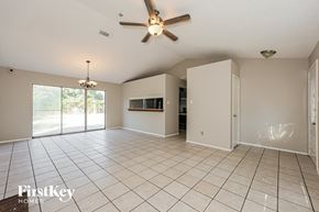 Fort Worth house for rent - A spacious room with a ceiling fan and sliding glass doors.