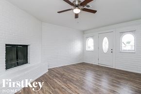 Phoenix house for rent - A room with a fireplace and a ceiling fan.