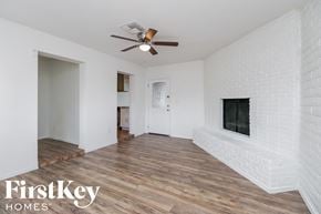 Phoenix house for rent - A room with a fireplace and a ceiling fan.