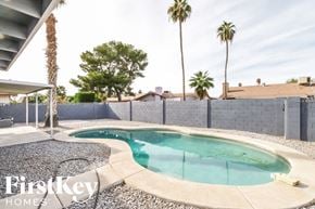 Phoenix house for rent - A pool surrounded by a concrete wall and a fence.