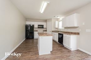 High Point house for rent - a kitchen with white cabinets and a black refrigerator