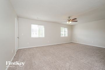 High Point house for rent - a spacious living room with carpet and a ceiling fan