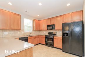 High Point house for rent - a kitchen with black appliances and wooden cabinets