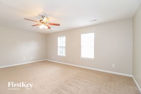 High Point house for rent - a bedroom with a ceiling fan and a carpeted floor