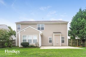 High Point house for rent - the front of a house with a green lawn and trees