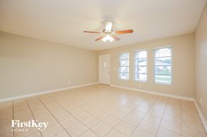 Cape Coral house for rent - a empty living room with a ceiling fan and a tiled floor
