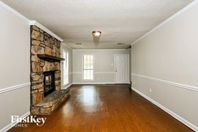 Memphis house for rent - A stone fireplace in a room with wooden floors and white walls.