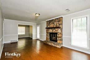 Memphis house for rent - A stone fireplace in a room with wooden floors and white walls.