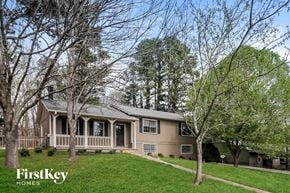 Marietta house for rent - A house with a porch and trees in front of it.