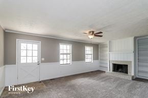 Marietta house for rent - A spacious room with a fireplace and a ceiling fan.