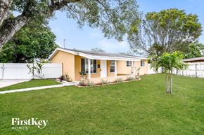 Fort Lauderdale house for rent - A house with a white fence and a tree in the front yard.