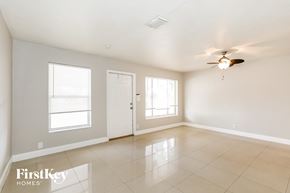 Fort Lauderdale house for rent - A spacious room with a ceiling fan and two windows.