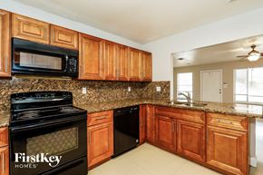 Fort Lauderdale house for rent - A kitchen with wooden cabinets and a black microwave.