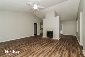 Douglasville house for rent - A spacious living room with wood flooring and a fireplace.
