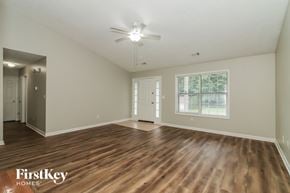 Douglasville house for rent - A spacious room with wooden floors and a ceiling fan.