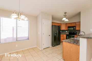 San Tan Valley house for rent - a kitchen with a large window and a black refrigerator