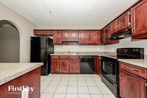 Decatur house for rent - a kitchen with wooden cabinets and black appliances