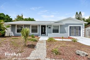 Bradenton house for rent - A house with a grey exterior and a black door is for sale.