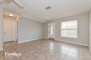 Bradenton house for rent - A spacious empty room with tile flooring and two doors.