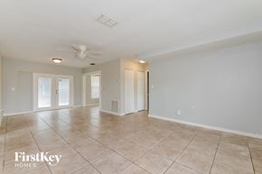 Bradenton house for rent - A spacious room with a fan and tiled flooring.