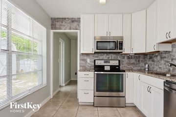Bradenton house for rent - A kitchen with a stove, oven, microwave and cabinets.