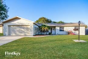 Valrico house for rent - a white house with a lawn and a white garage door