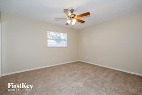 Valrico house for rent - a bedroom with beige carpet and a ceiling fan