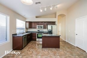 San Tan Valley house for rent - a kitchen with dark wood cabinets and a counter top