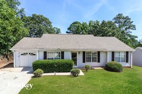 Rex house for rent - a white house with a lawn and a white garage door