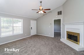 Rex house for rent - a living room with a fireplace and a ceiling fan