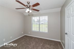 Rex house for rent - a bedroom with a ceiling fan and a window