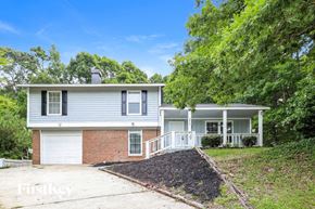 Conley house for rent - a white and brick house with a driveway and trees