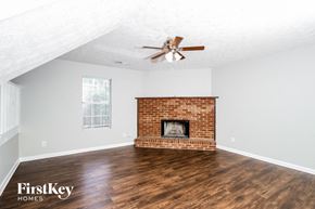 Conley house for rent - a living room with a brick fireplace and a ceiling fan