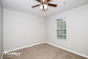 Conley house for rent - a bedroom with a ceiling fan and a window