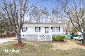Winston-Salem house for rent - A white house with a porch and a tree in front.