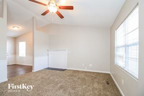 Winston-Salem house for rent - A carpeted room with a ceiling fan and a window.