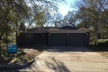 Dallas house for rent - the front of a house with a driveway and a garage door