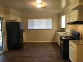 Dallas house for rent - an empty kitchen with black appliances and white cabinets
